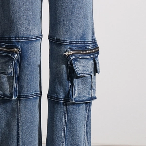 Detail of high-waisted cargo jeans with side flap pockets and silver metal zippers