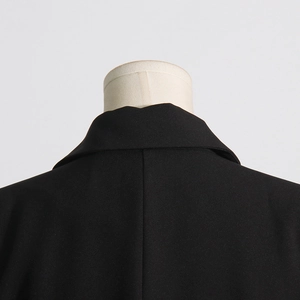 Detailed close-up of the collar and back stitching on this elegant black suit blazer