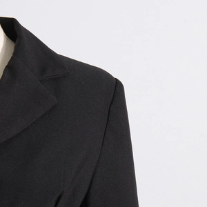 Detail of notched lapel and padded shoulder on black denim patchwork blazer
