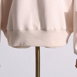 Detail of wide ribbed hem and premium stitching on cream sweatshirt for women