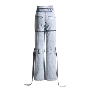 Détail du pantalon en jean délavé avec fermetures éclair et sangles à boucle métal