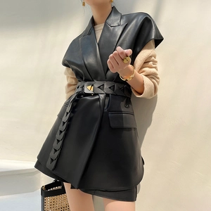 Dettaglio del gilet in ecopelle con revers e cintura in vita con fibbia a triangolo oro