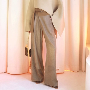Detail of high waist wide leg pants featuring wrap-around belt and metallic buckle
