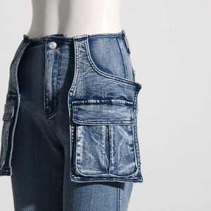 Detail of high waist denim pants with 3D cargo pockets and vintage acid wash texture