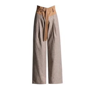Detailed close-up of high-waisted wide-leg pants featuring khaki waistband and metal buckle
