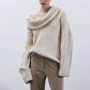 Detail of off-white ribbed knit sweater featuring an elegant off-shoulder collar design