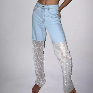Detail of high waist light blue denim jeans with silver sequin mesh leg panels