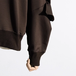 Detail of dark coffee sweatshirt showing ribbed cuffs and premium textured cotton fabric