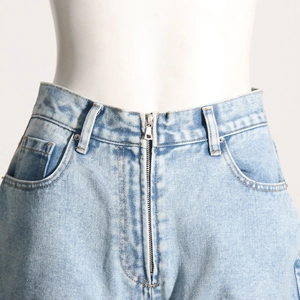 Vue détaillée du jean bleu clair montrant la taille, la braguette zippée et les poches