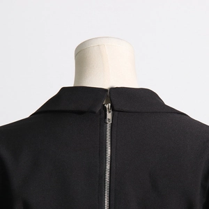 Detail of the back silver zipper closure and collar on black denim patchwork blazer
