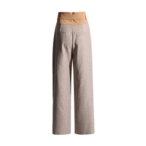 Detail of high-waist wide-leg pants showing back welt pockets and patchwork tweed fabric