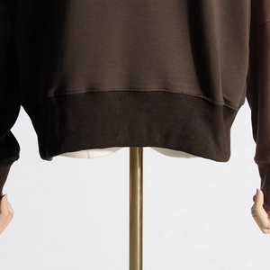 Detail shot of coffee brown sweatshirt showing ribbed elastic cuffs and hem craftsmanship