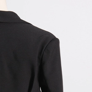 Close-up of structured shoulder and notch lapel on a black tailored blazer jacket