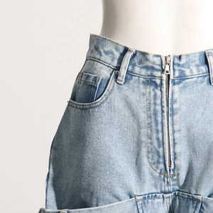 Détail d'un jean taille haute bleu clair délavé avec fermeture éclair et boucles de ceinture