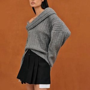 Close-up of grey loose-fit knit sweater with textured vertical stripes and off-shoulder cut