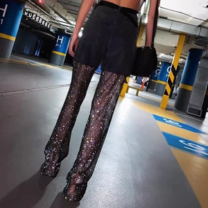 Close-up of high-waist mesh trousers with sparkling rhinestones and hollow-out fishnet detail
