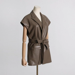 Dettaglio del gilet in pelle PU marrone con revers e cintura annodata in vita stile chic