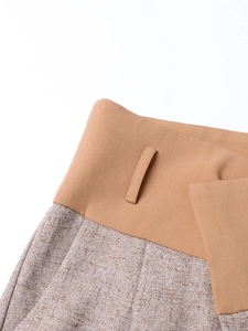 Macro detail of high waist contrast stitching with tan fabric and textured tweed paneling