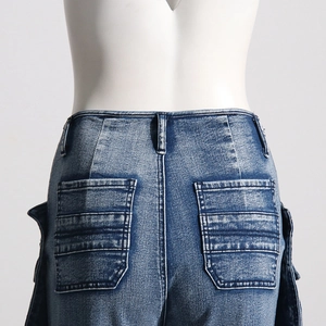 Close-up of rear pockets and cargo stitching on high-waist washed blue denim pants