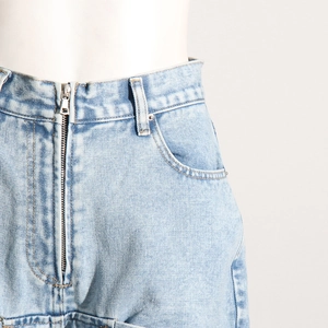 Détail de la taille d'une jupe en jean bleu clair avec fermeture éclair en métal