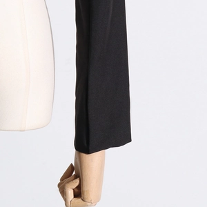 Close-up detail of the sleeve cuff on a black tailored blazer with premium woven texture