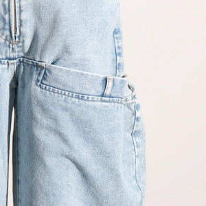 Détail du jean bleu clair à taille haute avec fermeture éclair et poches latérales