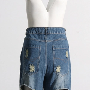 Dettaglio delle tasche posteriori dei jeans in denim con strappi e vita alta