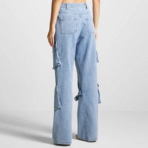 Detail of high-waist light blue cargo jeans showing large side pockets and strap accents