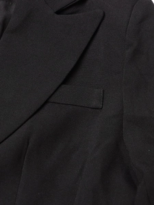 Macro detail of high-quality black woven fabric on blazer showing lapel and pocket texture