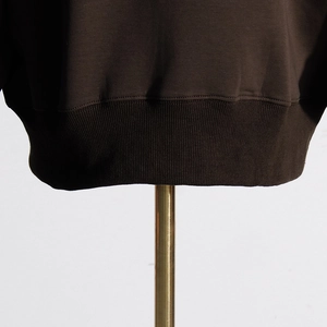 Detail of the dark brown ribbed hem and fine stitching on a stylish women sweatshirt