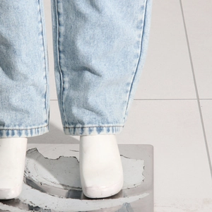 Détail d'un jean délavé bleu clair montrant l'ourlet droit et les coutures de précision