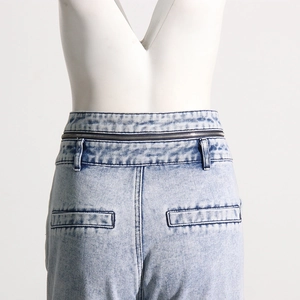 Détail arrière d'un jean délavé bleu clair avec double taille unique et fermeture éclair métal