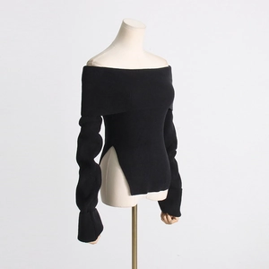 Detail eines schwarzen schulterfreien Strickoberteils mit Rippmuster und Seitenschlitz