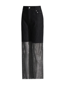 Detail of high-waisted black denim jeans with silver sequin mesh patchwork design