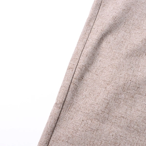 Detailed view of high-waist trousers showing brown textured fabric and sewing craftsmanship