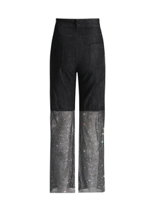 Detail showing high waist black denim pants with sparkling rhinestone mesh hollow-out design