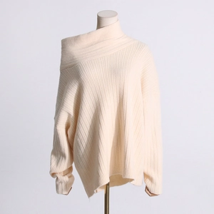 Detailed macro view of cream off-shoulder knit sweater with ribbed texture and asymmetric neck