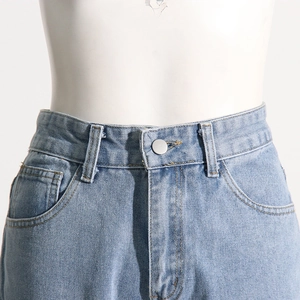 Detail of high-waisted light blue denim jeans showing metal button and curved pocket stitching
