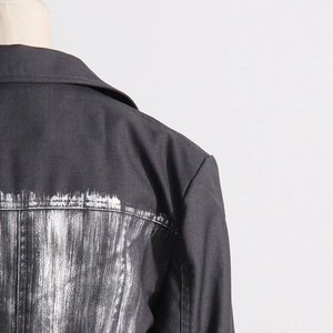 Vue détaillée du dos d'un blazer noir avec une finition artistique peinte en argent