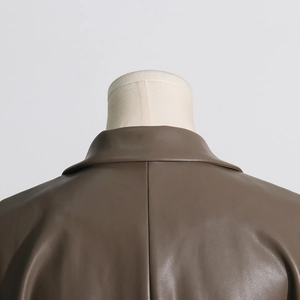Dettaglio del colletto del gilet in similpelle marrone con cuciture fini su manichino