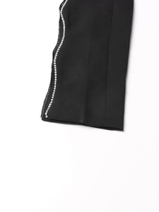 Detail of elegant black suit sleeve featuring a row of sparkling silver rhinestone trim