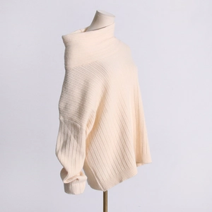 Close-up of beige knit sweater showing vertical rib texture and slouchy neckline details