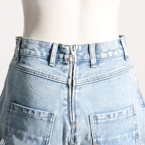 Détail du jean bleu clair taille haute avec fermeture éclair métallique au dos et poches