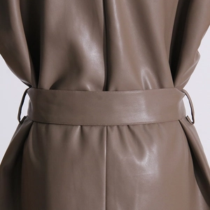 Dettaglio della cintura e cuciture su gilet marrone in pelle PU con fibbia