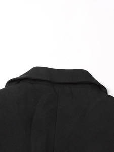 Detail shot of black tailored blazer featuring a classic notched lapel and woven fabric