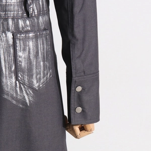 Détail de la veste grise avec finition métallique peinte à la main et boutons en métal