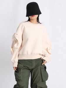 Chic beige crewneck sweatshirt with oversized bow sleeves paired with cargo pants