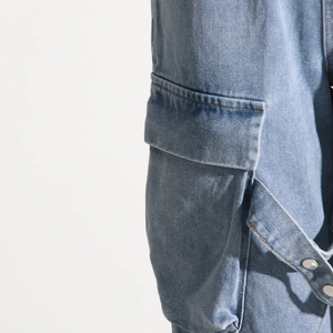 Detailed close-up of light blue cargo denim pocket with silver snap and stitching detail