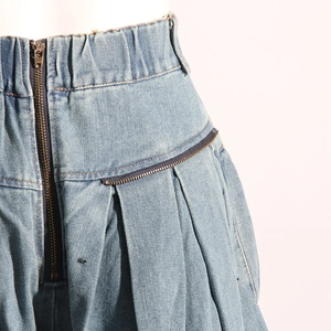 Macro de la taille en jean bleu clair avec fermetures éclair bronze et plis détaillés