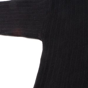 Detailed macro view of the black ribbed knit fabric and sleeve stitching texture